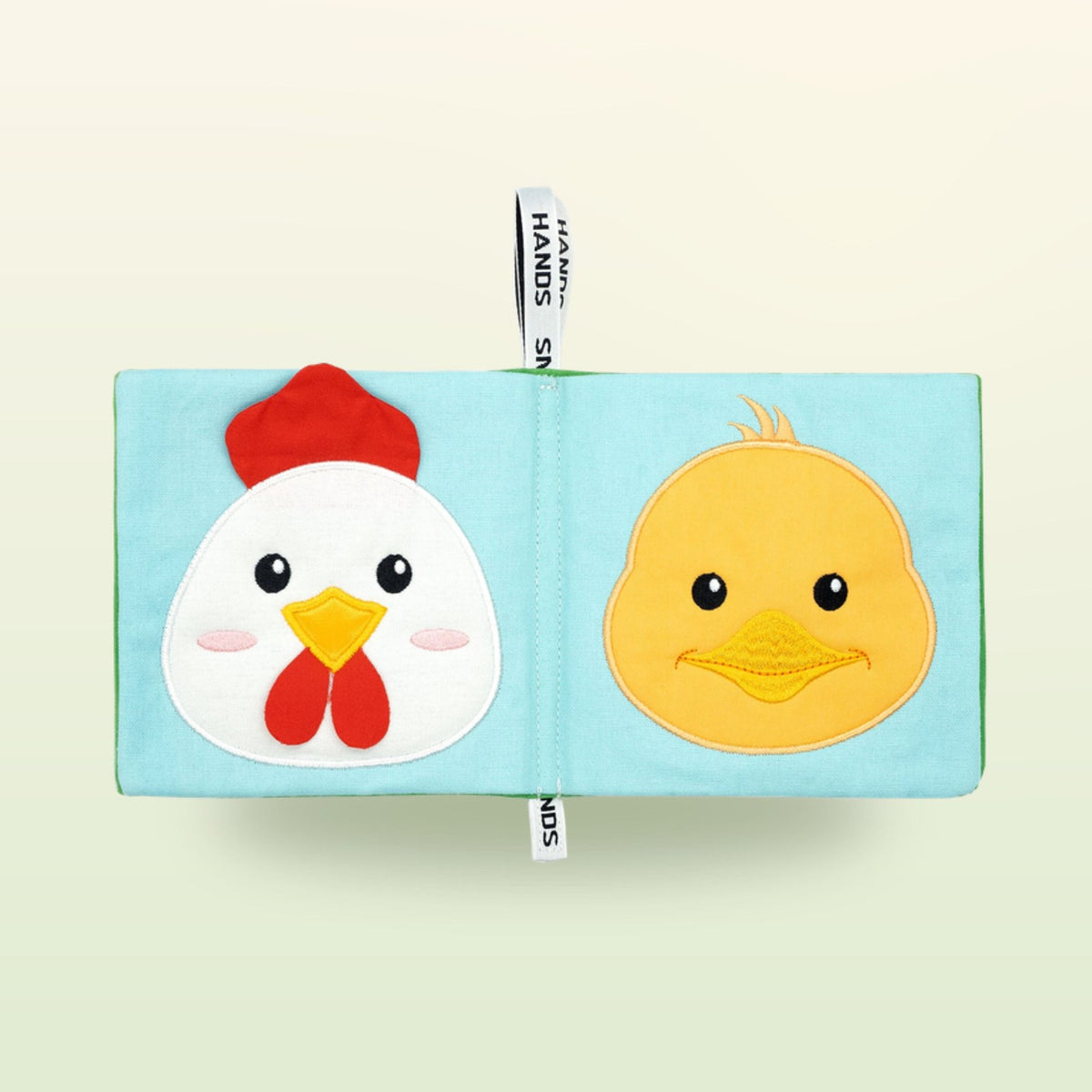 My First Book Small Hands Farm cloth book double page with hen and chick on a soft meadow green background – from 0 months