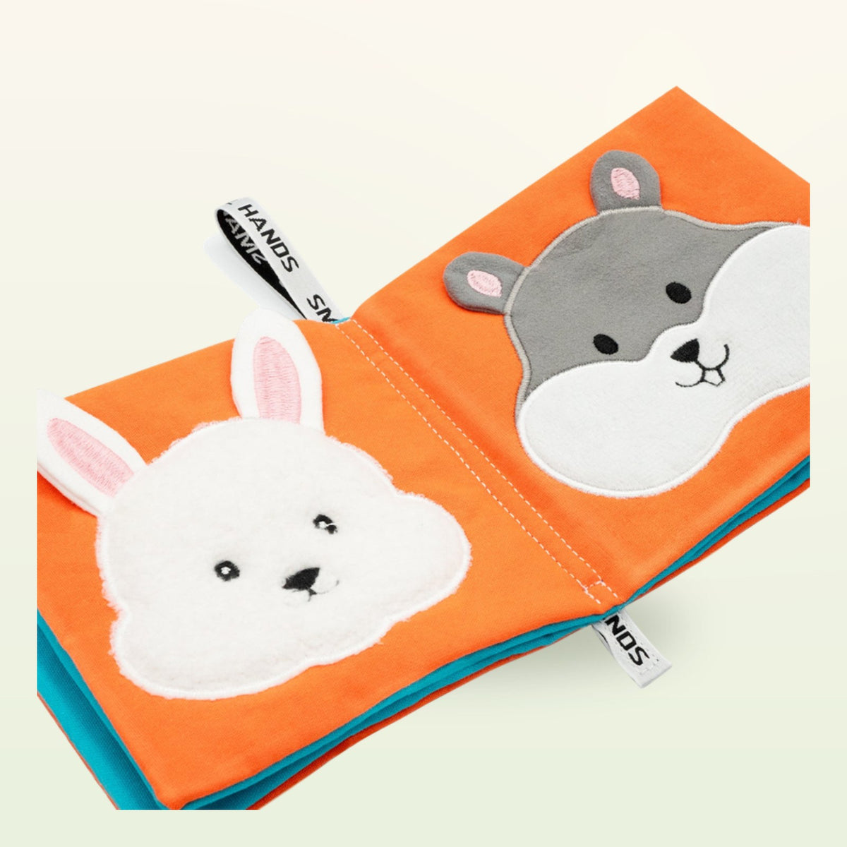 Small Hands Pets Montessori cloth book – close-up with white rabbit and grey hamster on a soft cream background – from 0 months