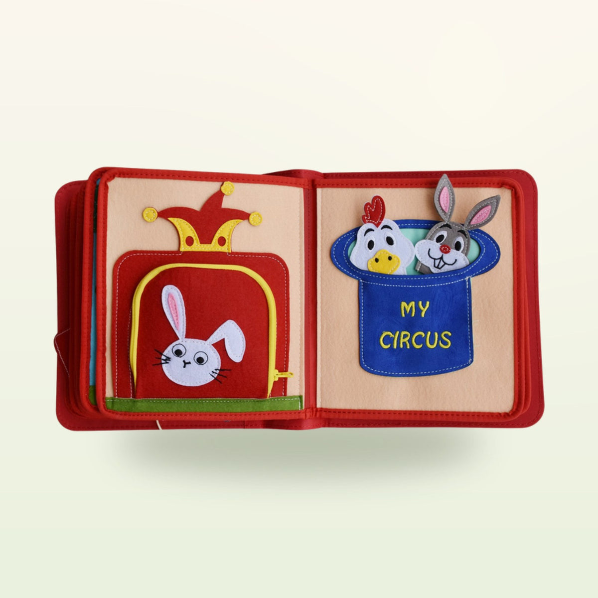 Circus Adventure quiet book magic box double page with rabbit in the top hat and My Circus pocket with animal finger puppets on a soft cream background – from 3 years