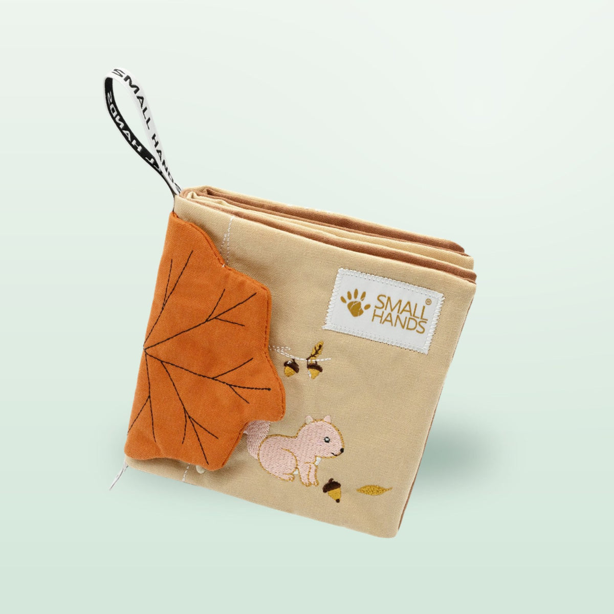 Small Hands Wild Animals sensory cloth book standing with stacked fabric pages on a soft forest green background – from 0 months