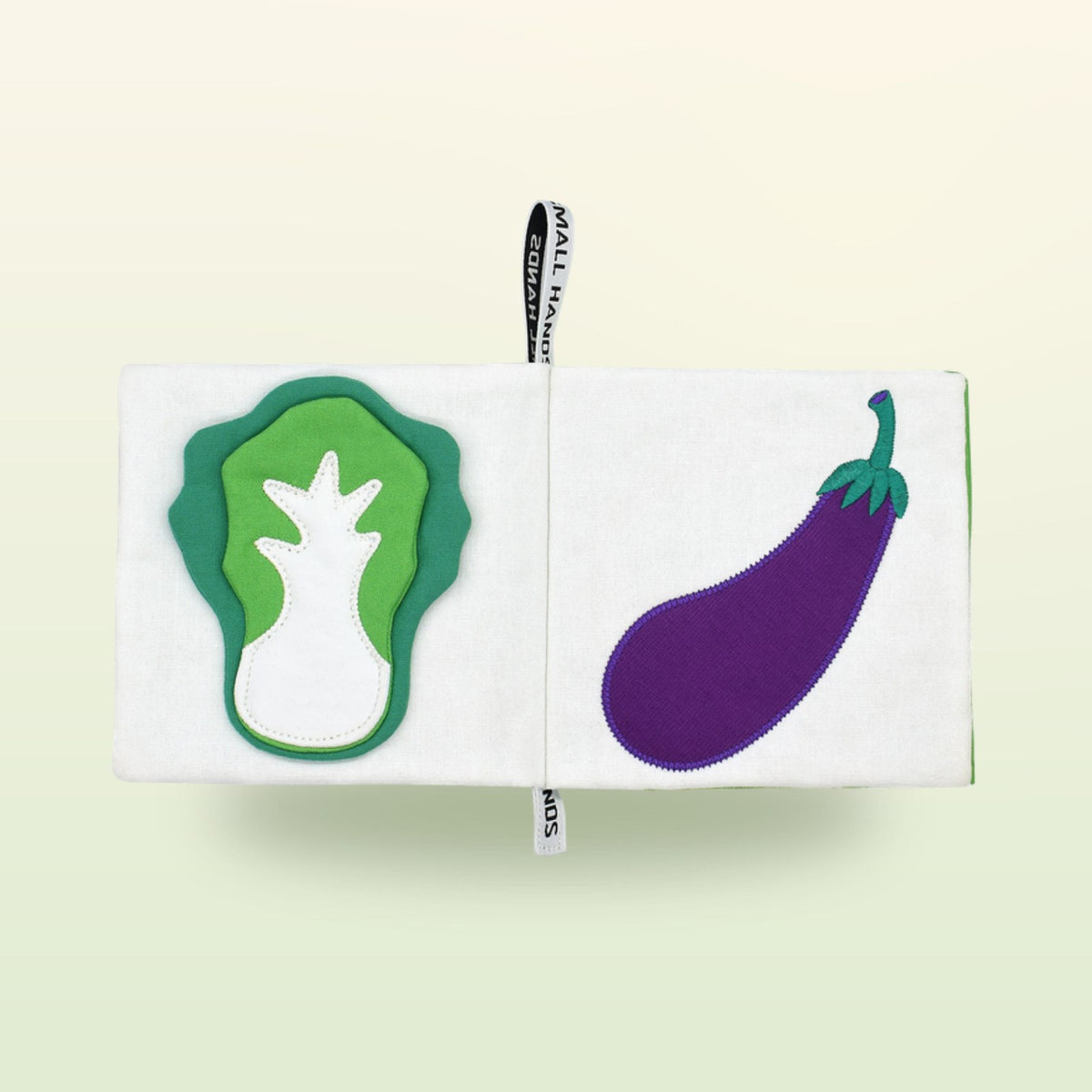 Small Hands Vegetables Montessori cloth book double page with cabbage and eggplant on a soft meadow green background – from 1 year