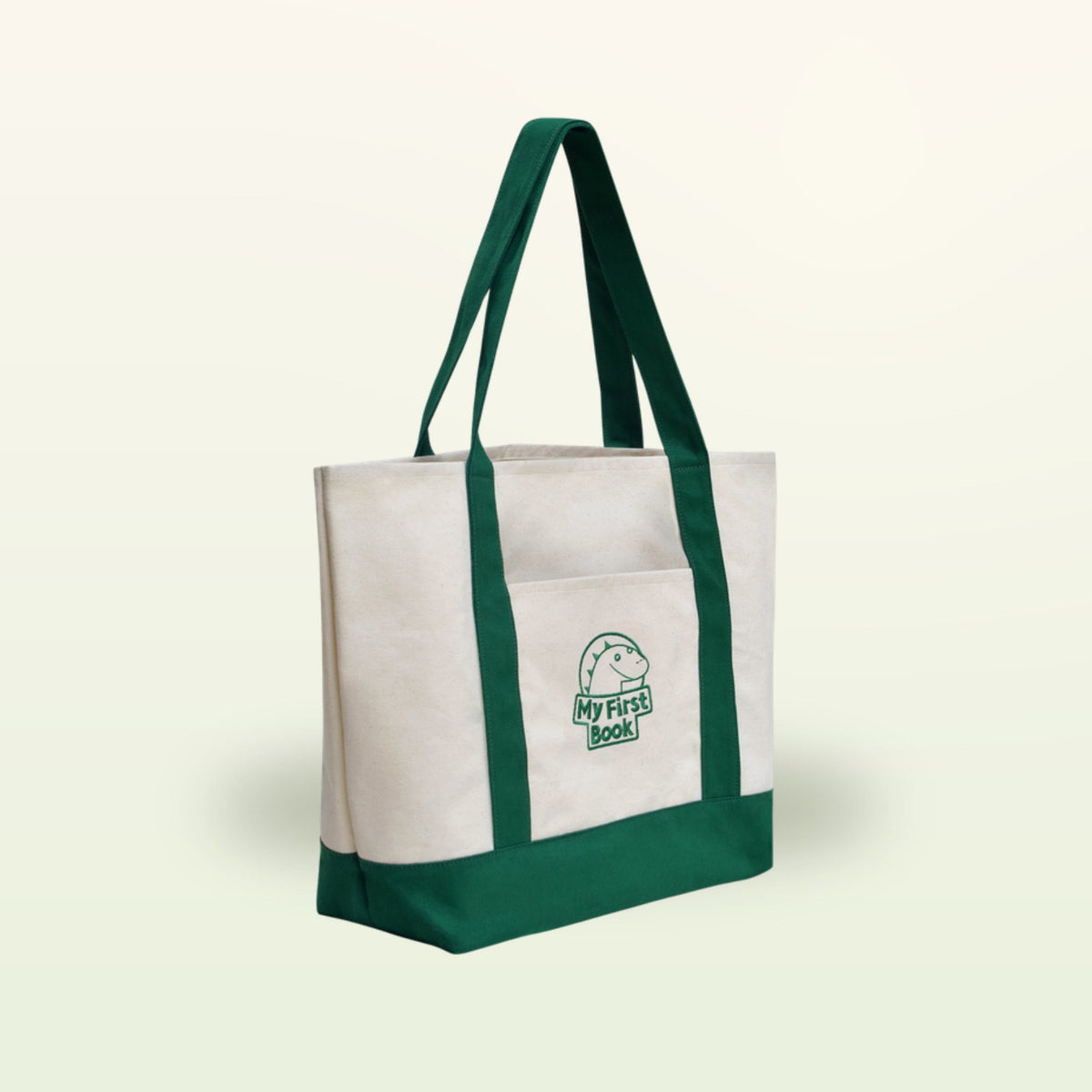 My First Book tote bag – cream fabric bag with green handles on a soft cream background
