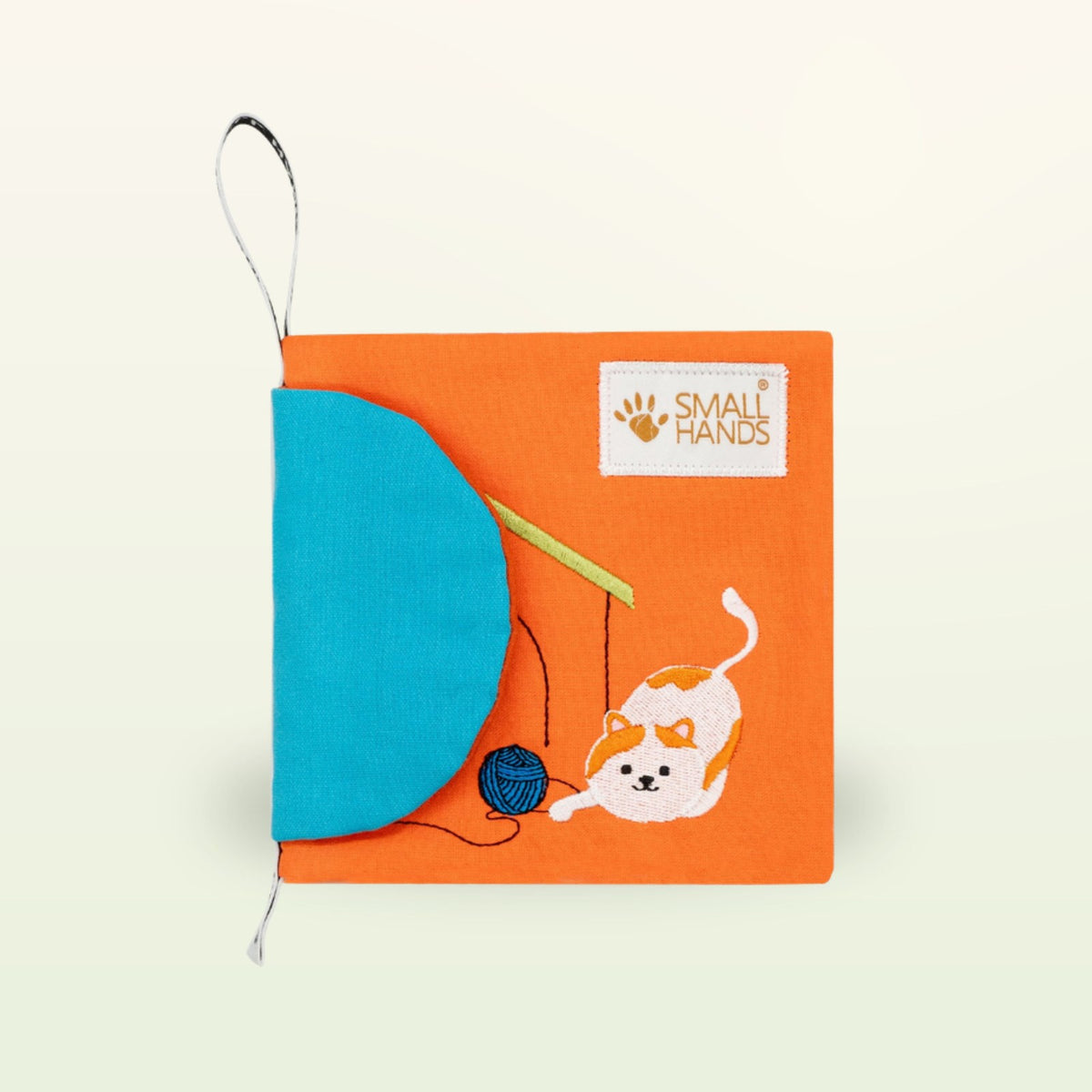 Small Hands Pets Montessori cloth book – cover with cat and blue ball of yarn on a soft cream background – from 0 months