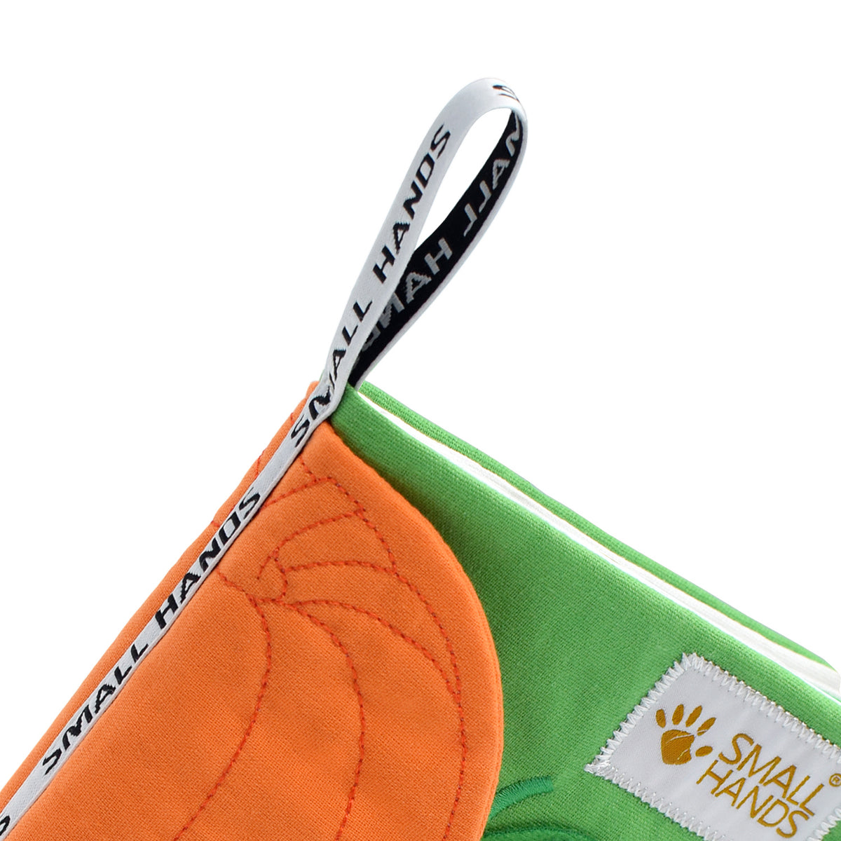 Vegetables Montessori sensory cloth book by Small Hands – close-up of the printed SMALL HANDS fabric hanging loop on the green cover with orange pumpkin