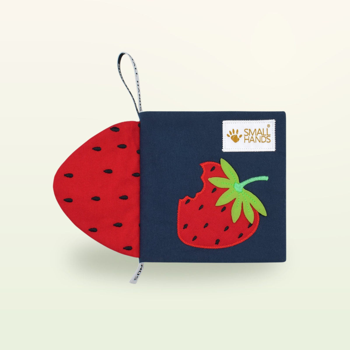 Small Hands Colorful Fruits Montessori cloth book – navy blue cover with red strawberry on a soft cream background – from 0 months