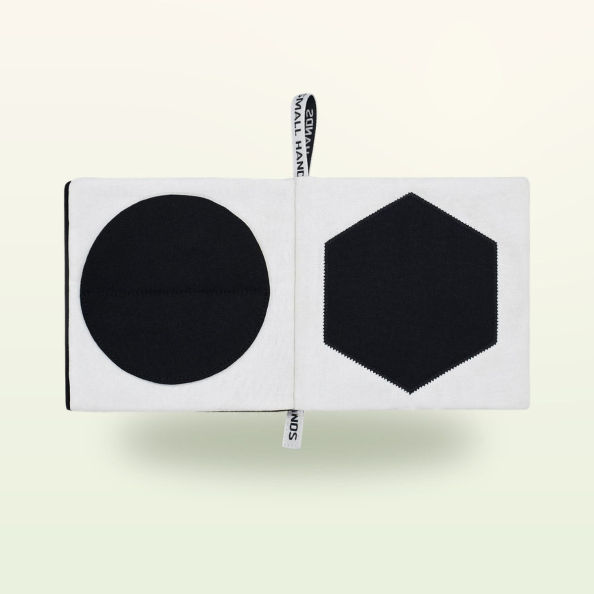 Small Hands Shapes contrast book open – black circle and hexagon on a soft cream background – from 0 months