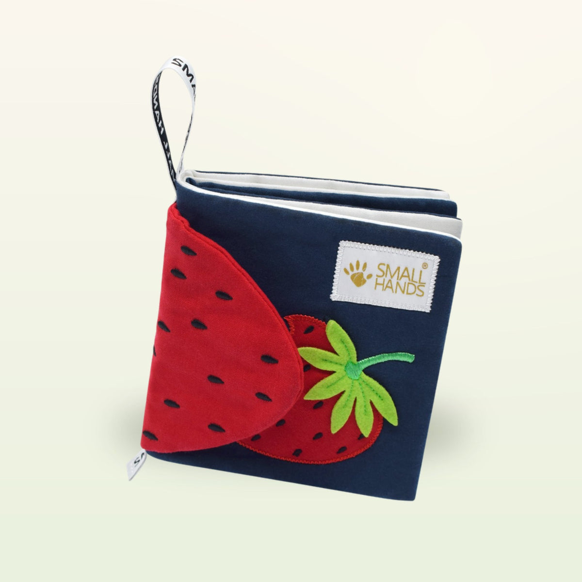 Small Hands Colorful Fruits Montessori cloth book standing upright with red strawberry on a soft cream background – from 0 months