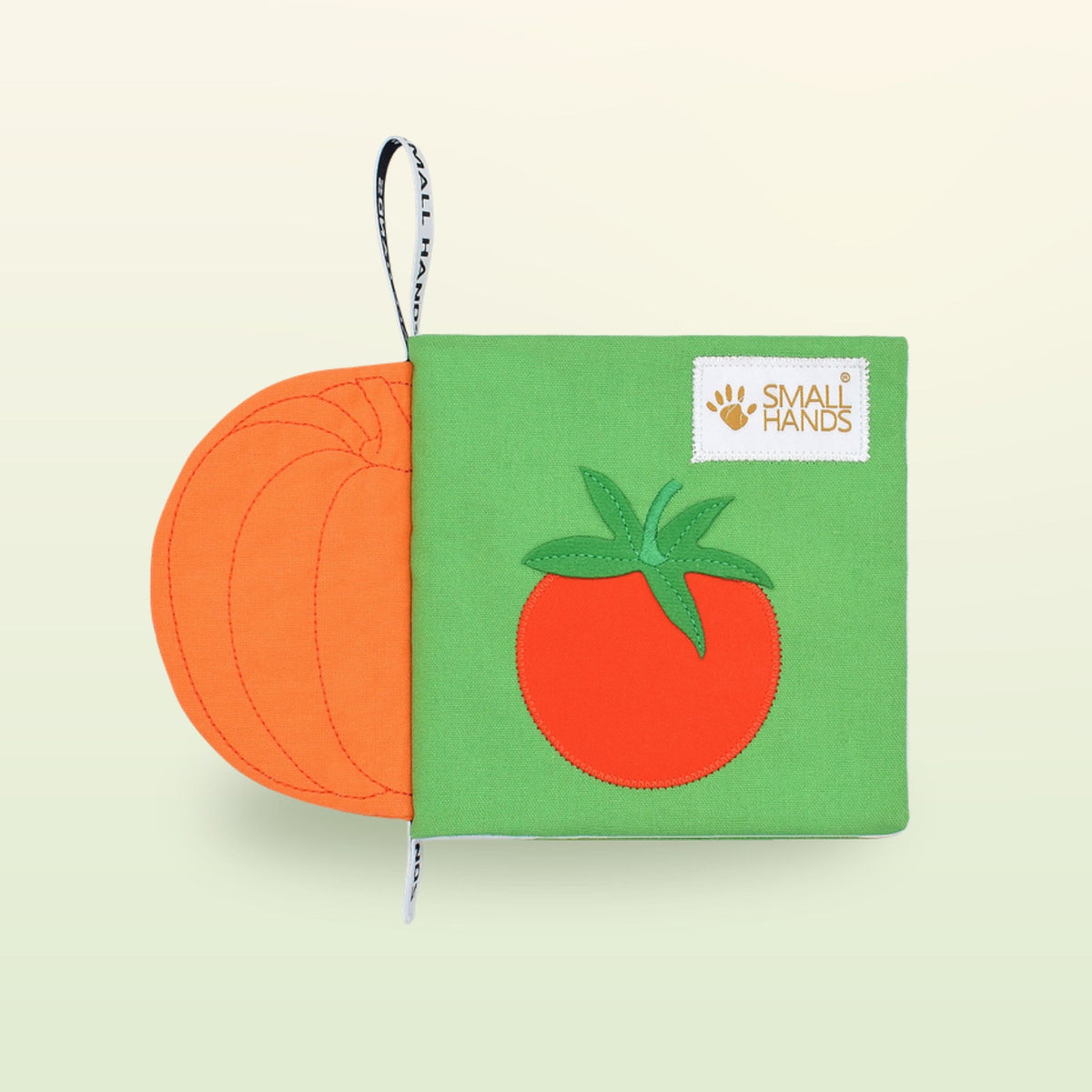 Small Hands Vegetables Montessori cloth book cover with tomato and pumpkin on a soft meadow green background – from 1 year