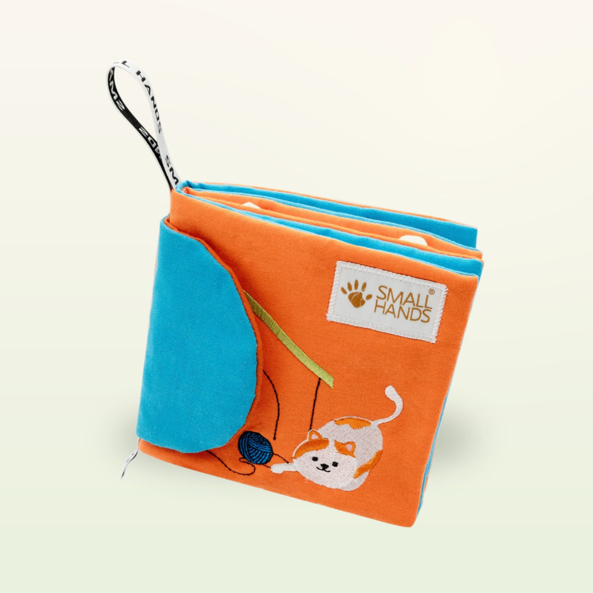 Small Hands Pets Montessori cloth book at an angle with stacked fabric pages and cat on a soft cream background – from 0 months