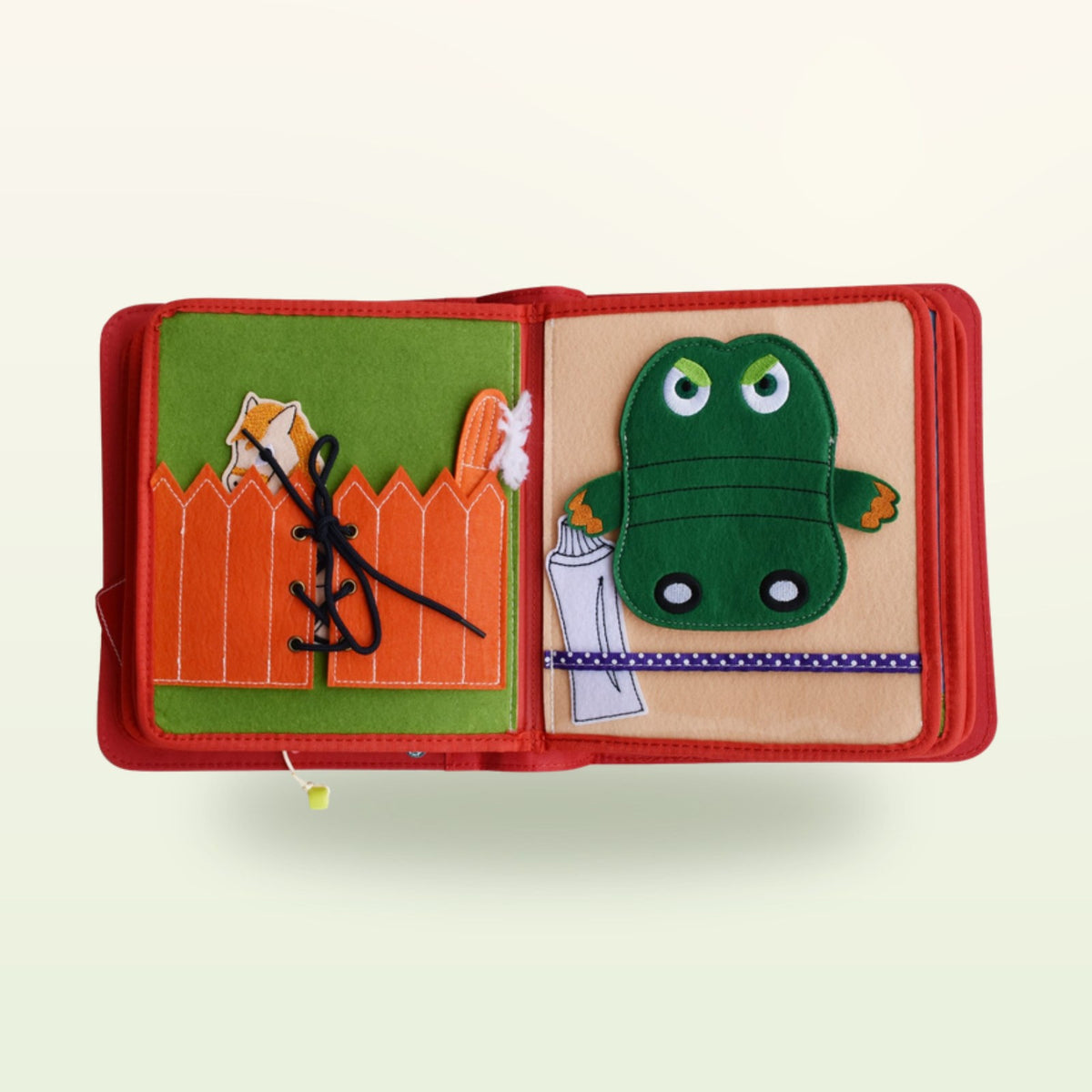 Circus Adventure quiet book double page with orange fence to lace and green crocodile to brush its teeth on a soft cream background – from 3 years