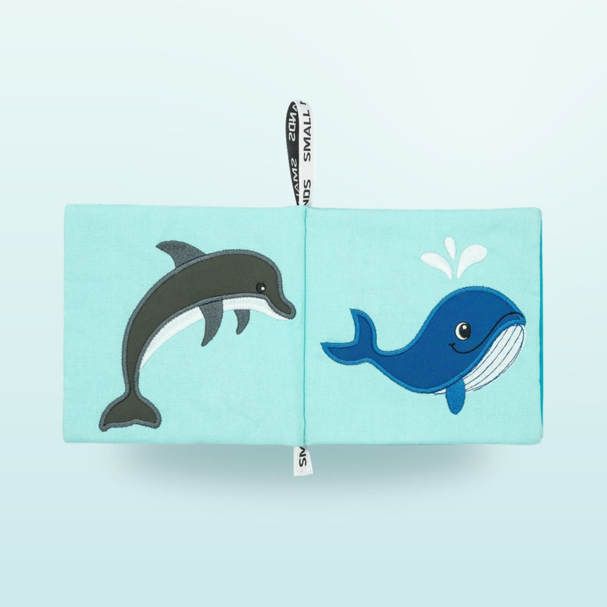 Small Hands Sea Animals Montessori cloth book double page with dolphin and whale on a soft underwater blue background – from 1 year