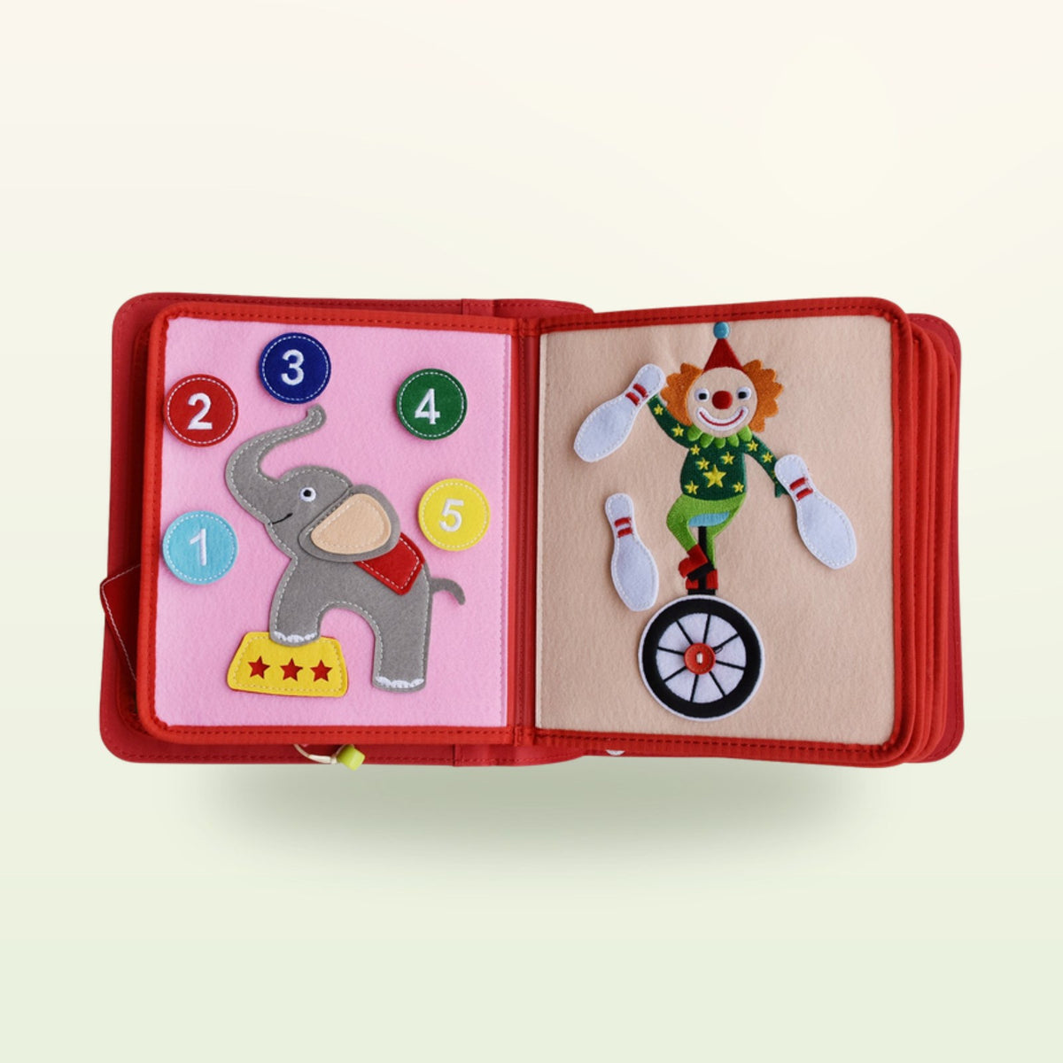 Circus Adventure quiet book counting double page with elephant with number buttons 1 to 5 and juggling clown on a unicycle on a soft cream background – from 3 years