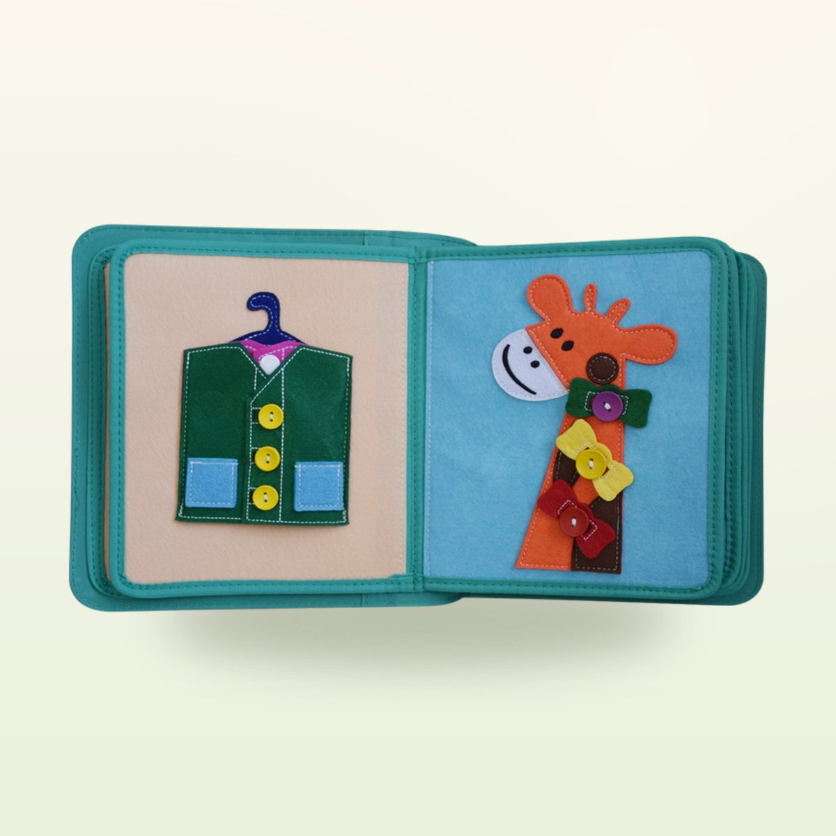 Dressing book fabric page with green button waistcoat on a hanger and giraffe with colourful buttons on a soft cream background – from 3 years