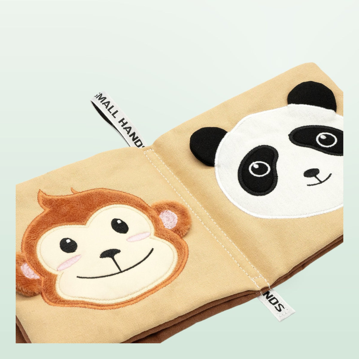 Small Hands Wild Animals sensory cloth book close-up with monkey and panda on a soft forest green background – from 0 months