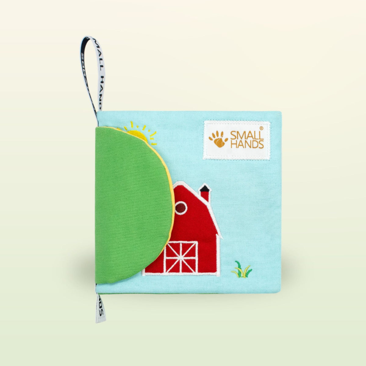 My First Book Small Hands Farm cloth book cover with red barn on a soft meadow green background – from 0 months