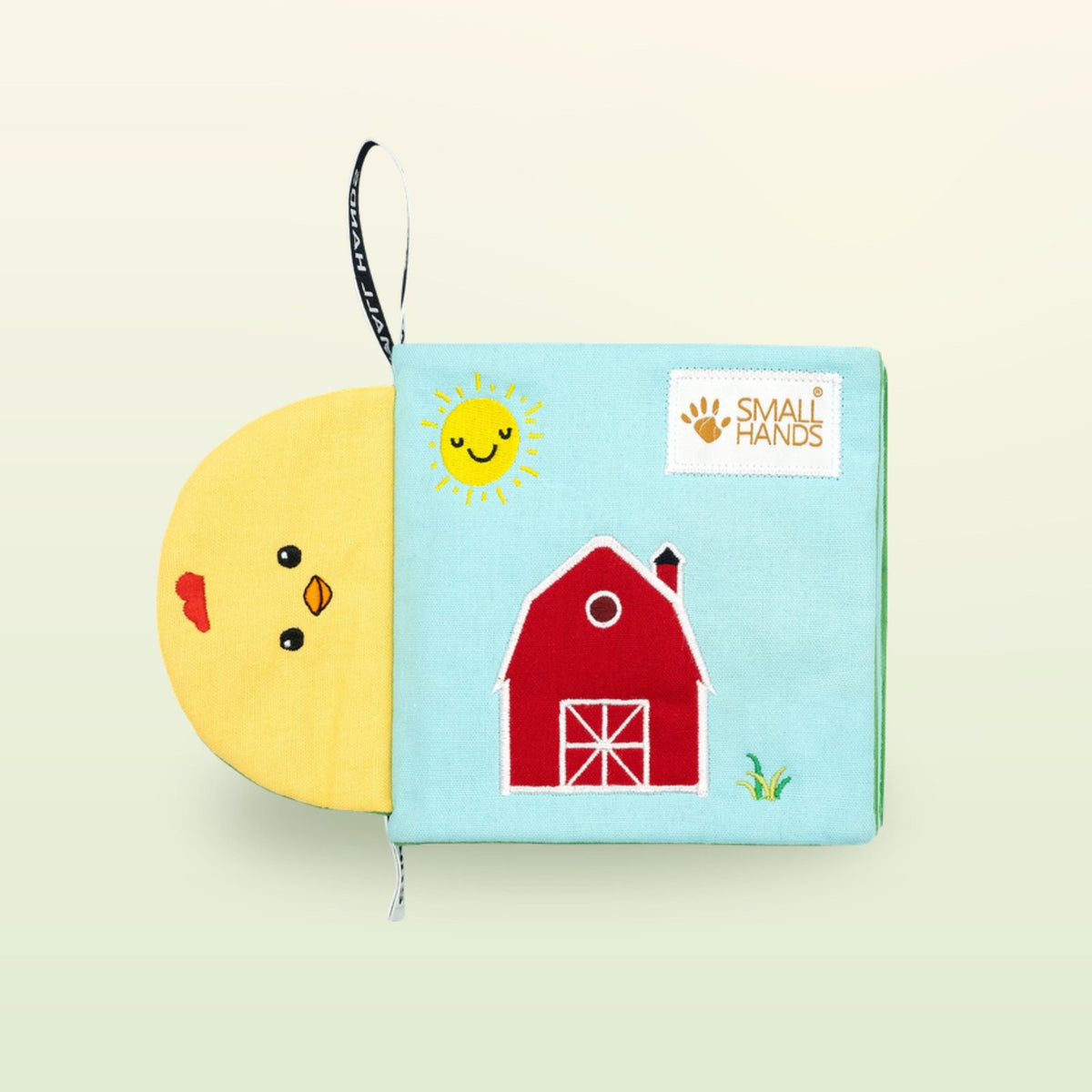 My First Book Small Hands Farm cloth book cover with barn and sun on a soft meadow green background – from 0 months