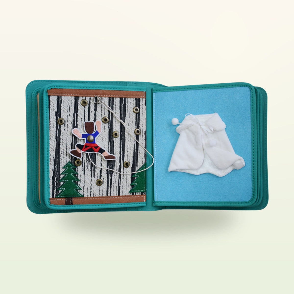 Dressing book fabric page with threading figure on the tree with press studs and white winter coat on a soft cream background – from 3 years